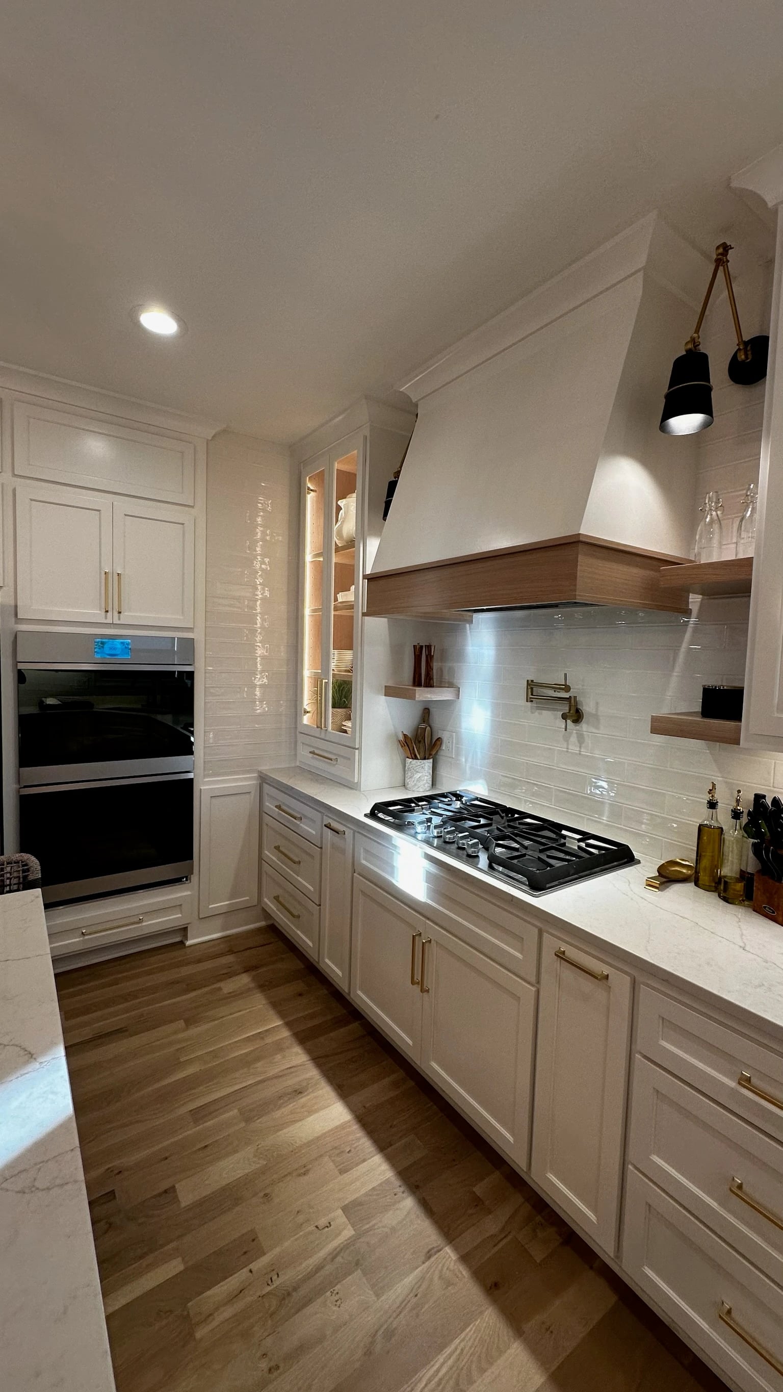 White kitchen cabinetry, hood, ovens and pot filler