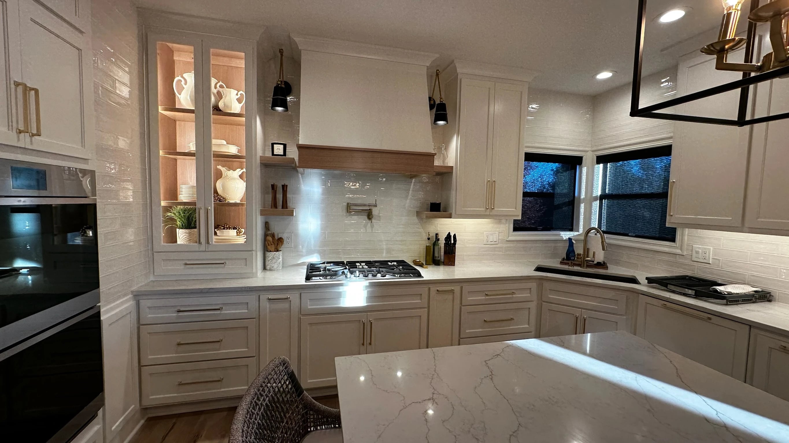 White kitchen range wall and lit display cabinetry