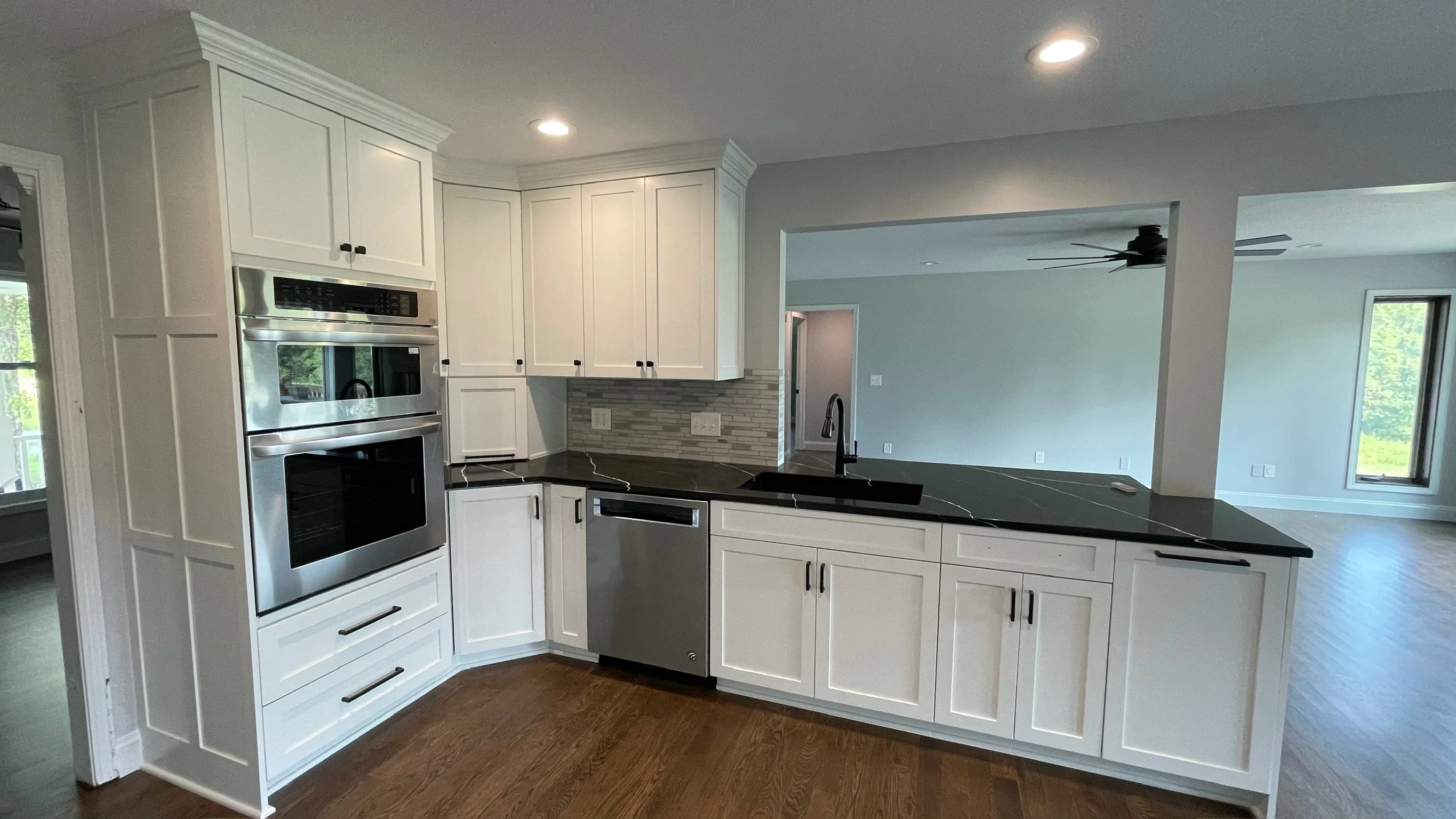 White kitchen cabinets, built-in ovens and dark counters