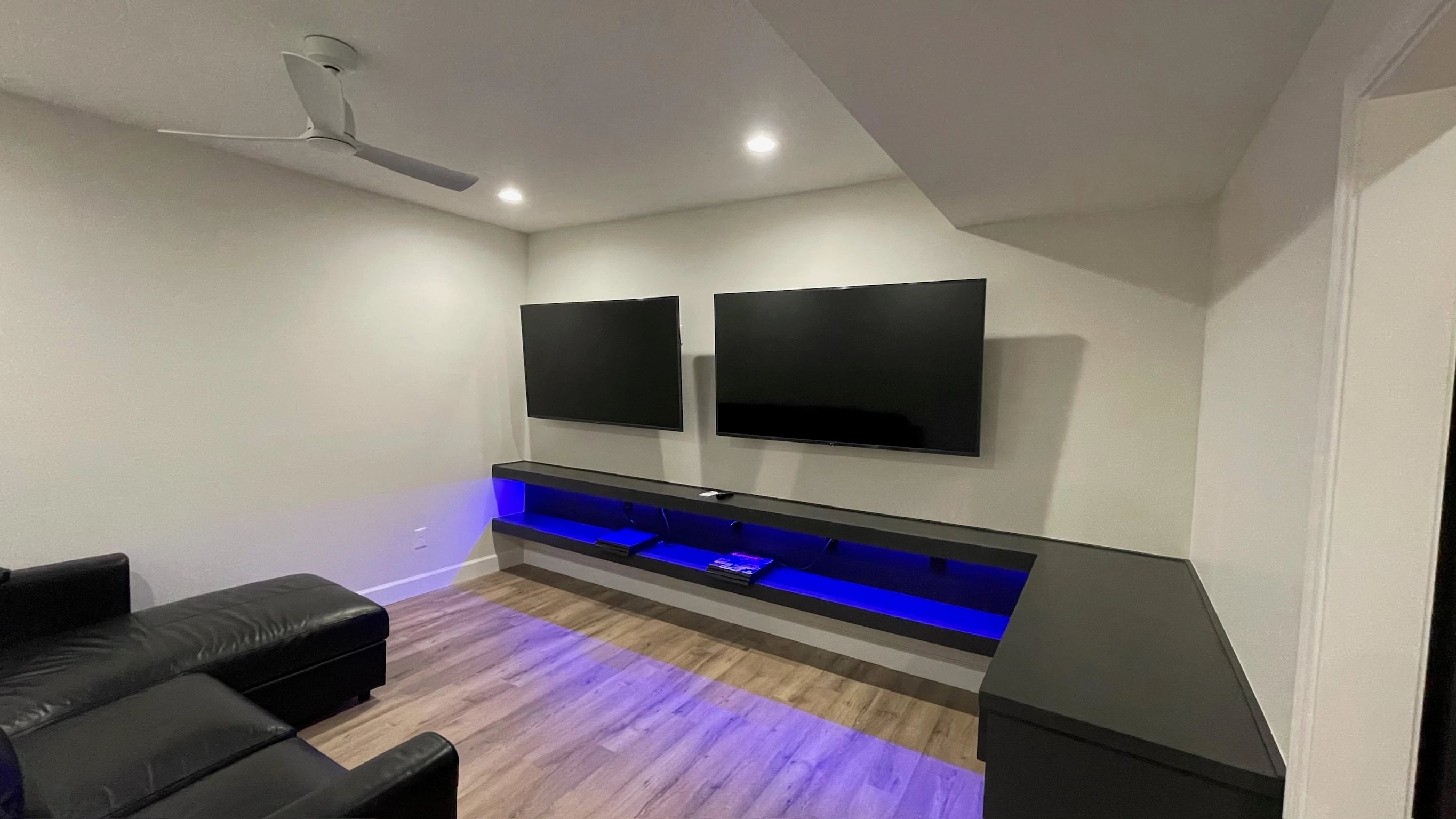 Dual-TV game area with LED-lit custom cabinetry