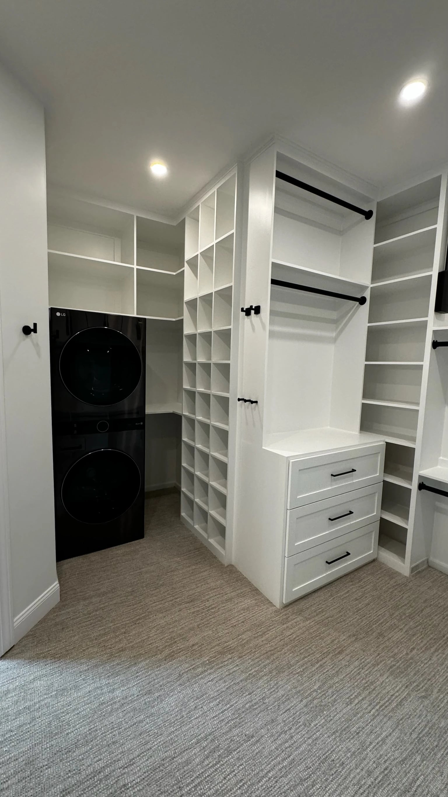Custom closet shelving beside stacked washer and dryer